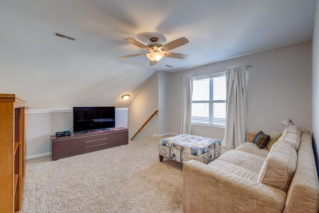 carpeted living room with ceiling fan and vaulted ceiling