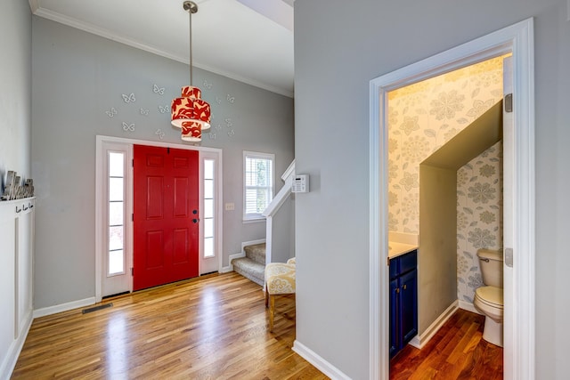 foyer featuring light wood-type flooring and crown molding