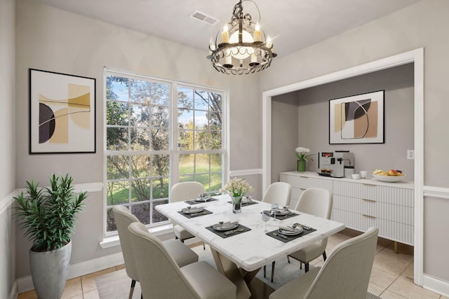 dining space with light tile patterned floors and a chandelier