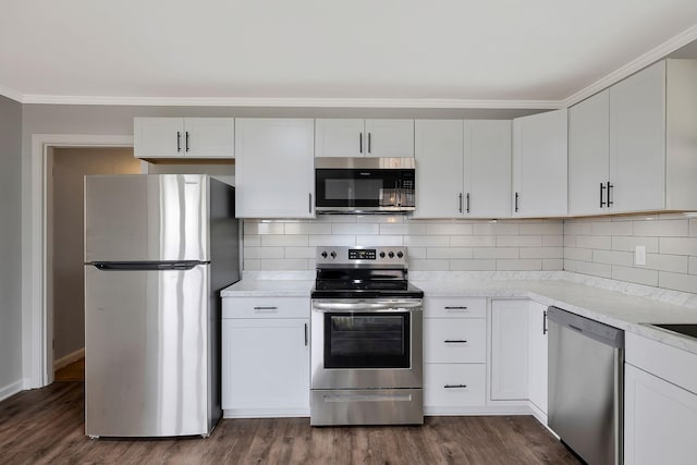 kitchen with backsplash, ornamental molding, stainless steel appliances, dark wood-type flooring, and white cabinets