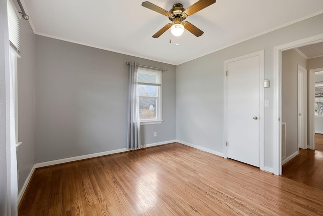 empty room with light hardwood / wood-style flooring, ceiling fan, and crown molding