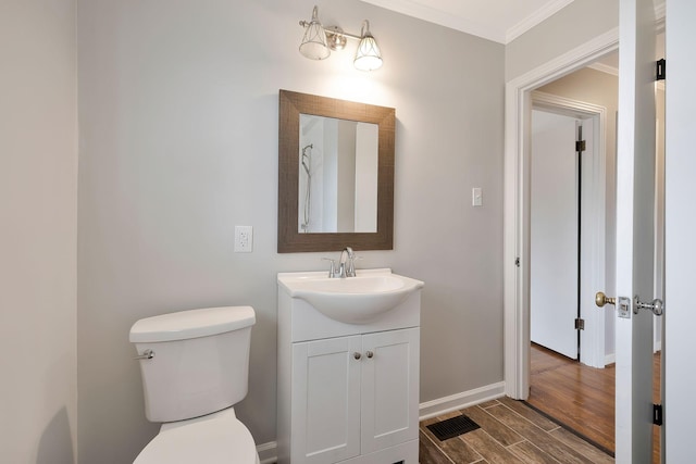 bathroom with vanity, toilet, wood-type flooring, and crown molding