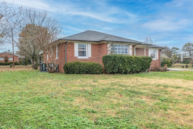 view of front of home with central AC and a front yard