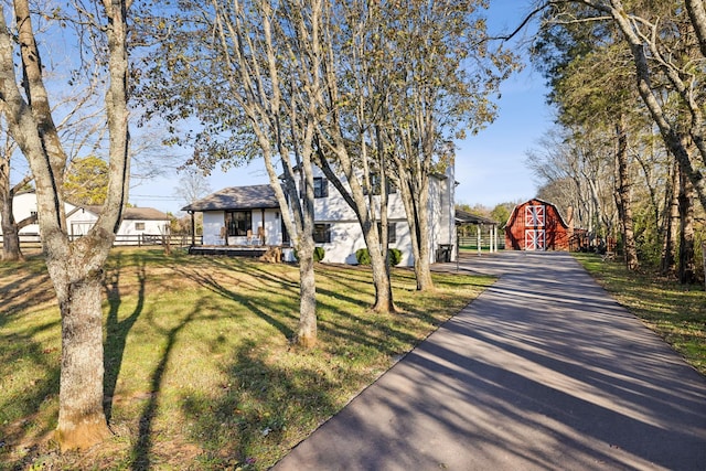 view of front of property featuring an outdoor structure and a front yard