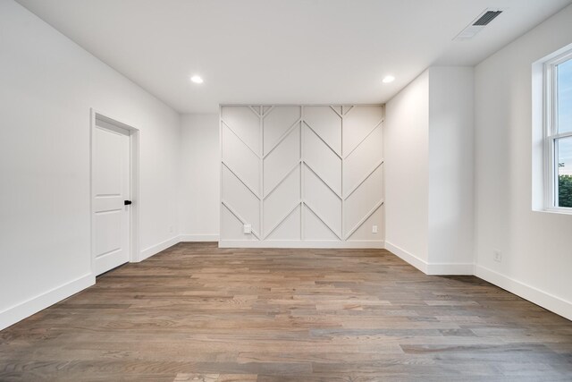 spare room featuring wood-type flooring and plenty of natural light