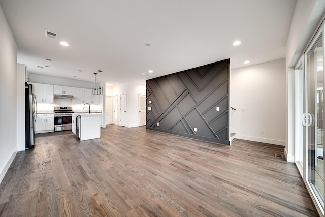 unfurnished living room with hardwood / wood-style flooring and sink