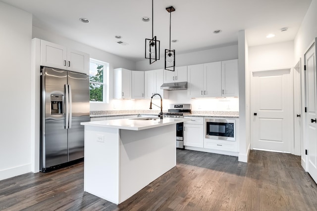 kitchen with appliances with stainless steel finishes, sink, decorative light fixtures, white cabinets, and an island with sink