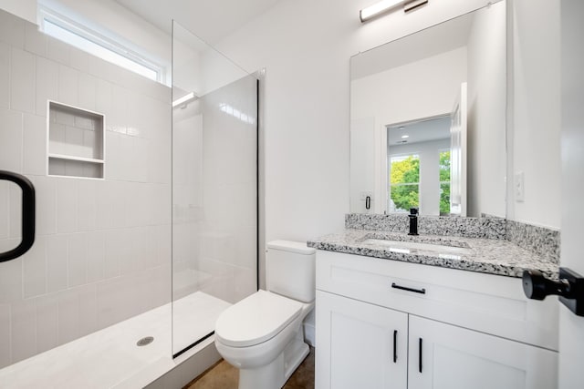 bathroom featuring vanity, an enclosed shower, and toilet