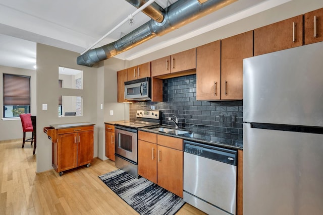 kitchen featuring tasteful backsplash, light hardwood / wood-style flooring, stainless steel appliances, and sink