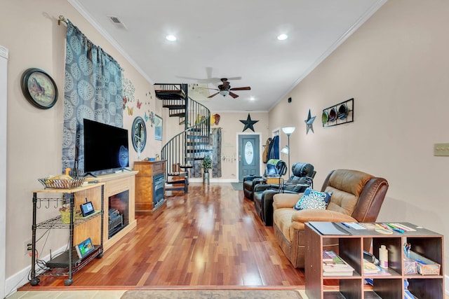 living room with hardwood / wood-style flooring, ceiling fan, and ornamental molding