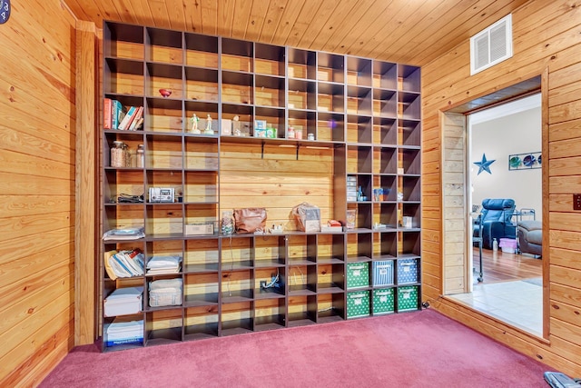 interior space with wooden walls, carpet floors, and wooden ceiling