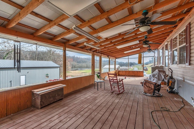 unfurnished sunroom featuring vaulted ceiling, a wealth of natural light, and ceiling fan