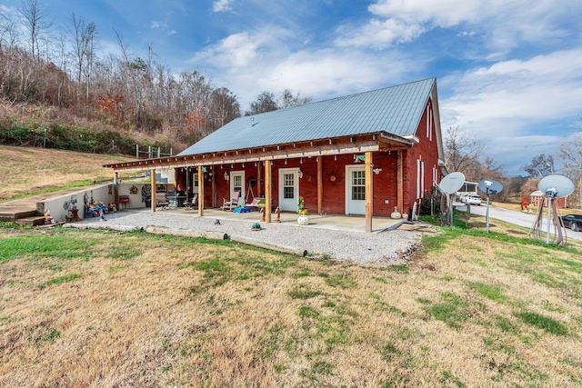 back of property with a yard and a patio