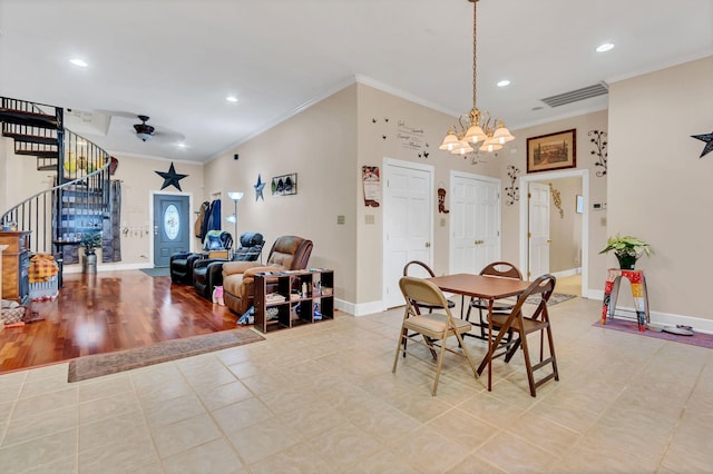 dining area with ceiling fan with notable chandelier, light hardwood / wood-style floors, and crown molding