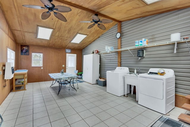 laundry room with washer and clothes dryer, ceiling fan, wooden ceiling, wood walls, and light tile patterned flooring