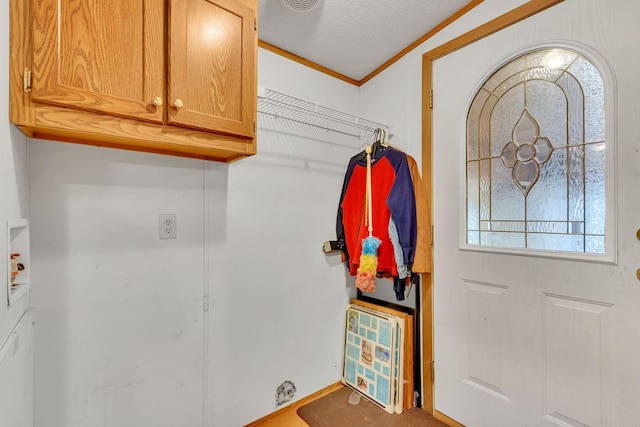 interior space with crown molding, hookup for a washing machine, cabinets, and a textured ceiling