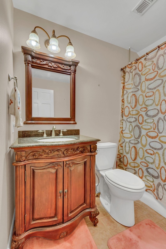 bathroom featuring tile patterned floors, vanity, toilet, and walk in shower