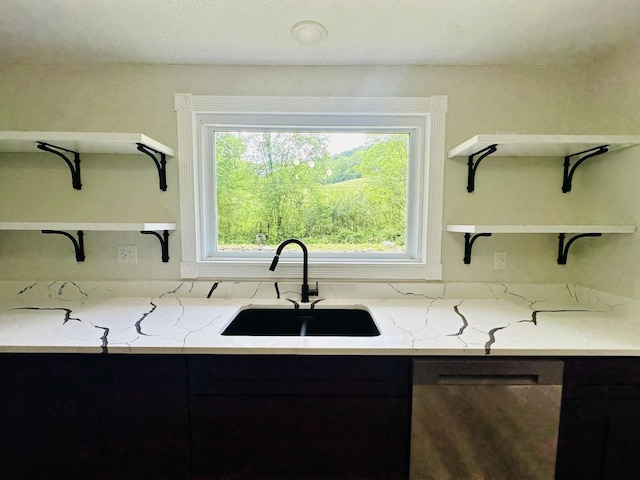 kitchen featuring light stone counters, sink, and stainless steel dishwasher