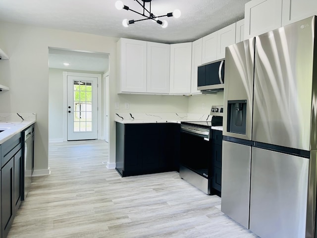 kitchen with light hardwood / wood-style flooring, white cabinets, a textured ceiling, and appliances with stainless steel finishes