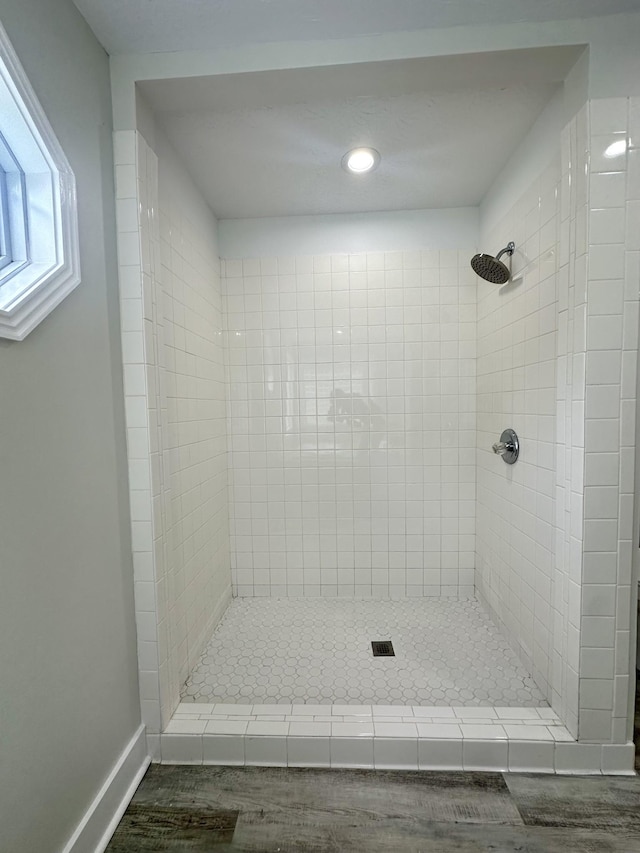 bathroom featuring hardwood / wood-style flooring and tiled shower