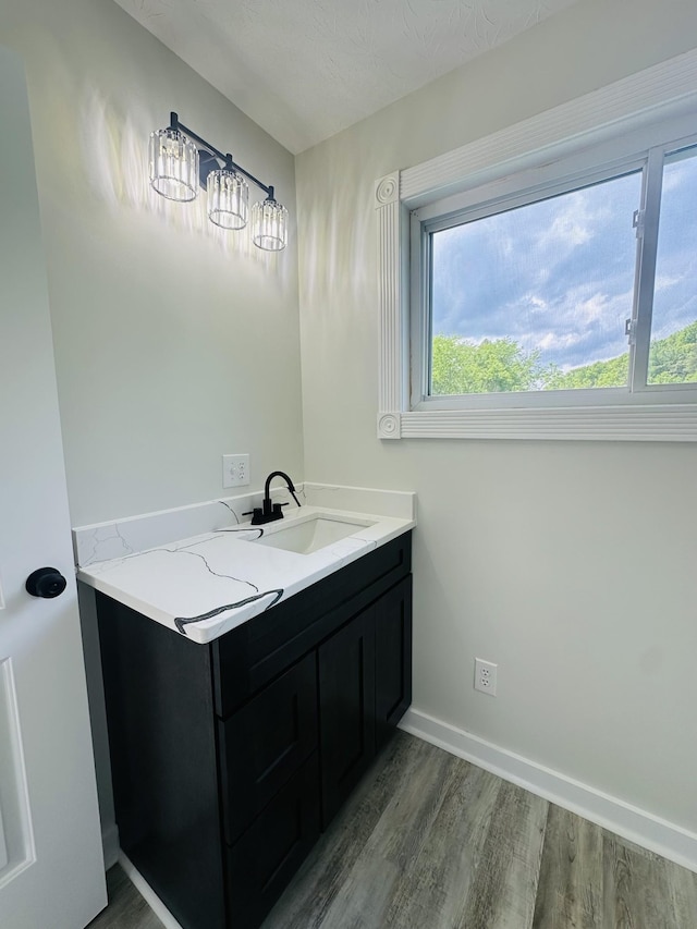 bathroom featuring hardwood / wood-style floors, vanity, and a textured ceiling