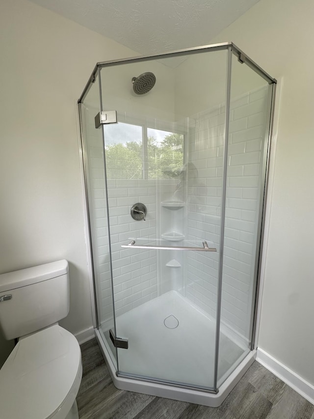 bathroom featuring hardwood / wood-style floors, a textured ceiling, toilet, and walk in shower