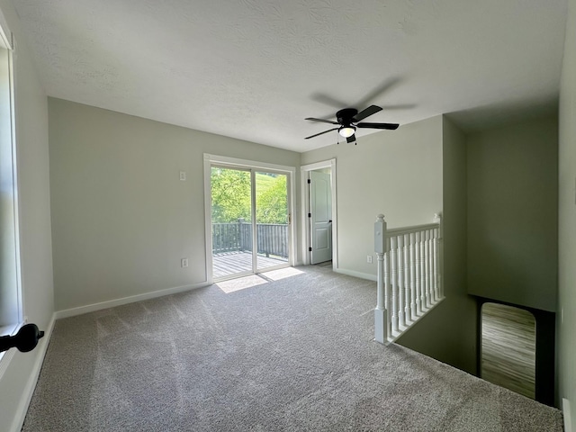 unfurnished room featuring ceiling fan, light colored carpet, and a textured ceiling