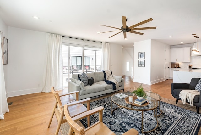 living room featuring light wood-type flooring and ceiling fan