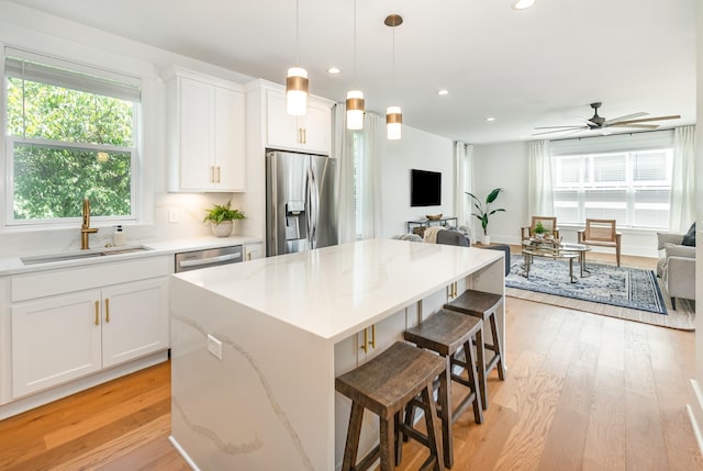 kitchen featuring a center island, sink, white cabinetry, and stainless steel appliances