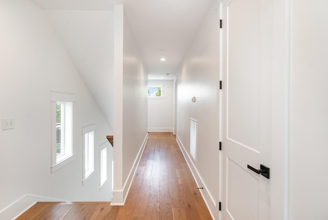 corridor featuring light hardwood / wood-style floors and vaulted ceiling