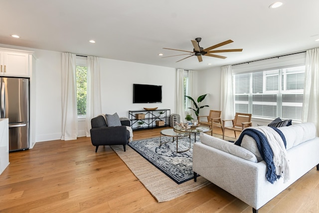 living room featuring ceiling fan and light hardwood / wood-style floors