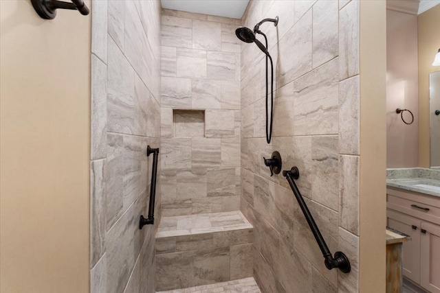 bathroom featuring tiled shower and vanity