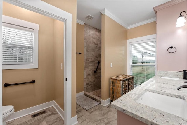 bathroom with tiled shower, vanity, ornamental molding, and toilet