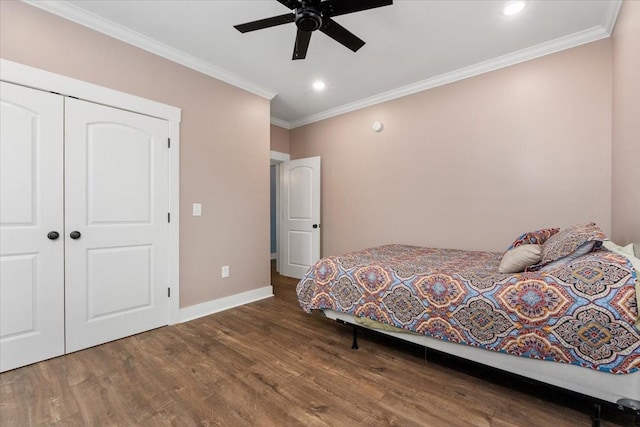 bedroom featuring ceiling fan, ornamental molding, dark wood-type flooring, and a closet