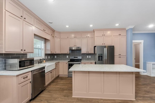 kitchen featuring appliances with stainless steel finishes, sink, a kitchen island, and wood-type flooring