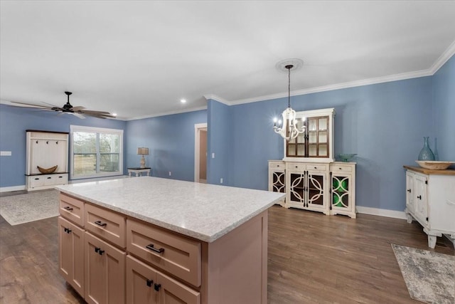 kitchen with dark wood-type flooring, ceiling fan with notable chandelier, ornamental molding, decorative light fixtures, and a kitchen island