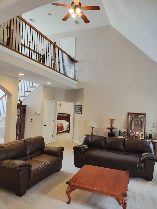 carpeted living room with high vaulted ceiling and ceiling fan