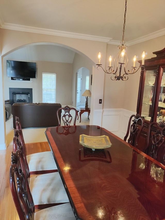 dining area featuring hardwood / wood-style flooring, ornamental molding, and a chandelier