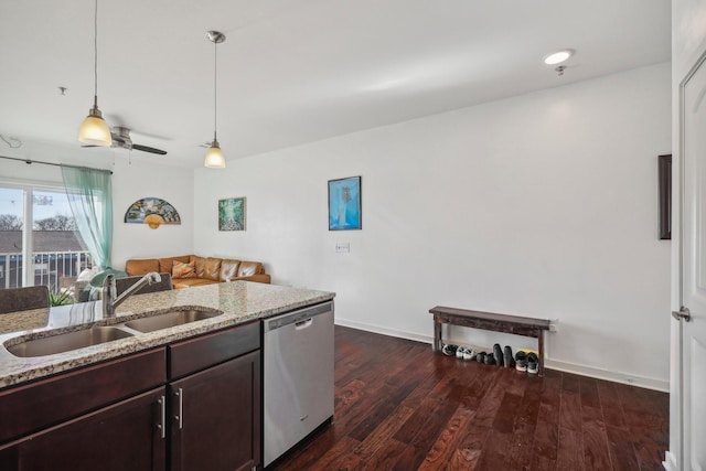 kitchen featuring light stone countertops, sink, hanging light fixtures, dark hardwood / wood-style flooring, and stainless steel dishwasher