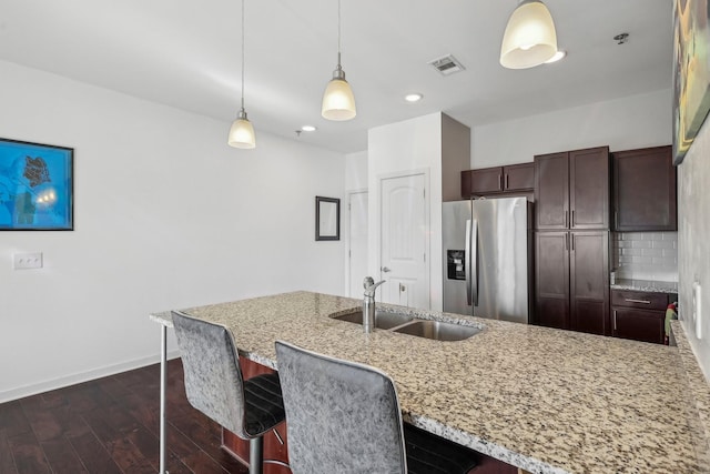 kitchen featuring dark brown cabinetry, dark wood-type flooring, sink, stainless steel fridge with ice dispenser, and hanging light fixtures