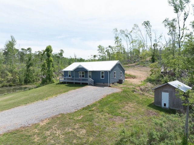 ranch-style home featuring a storage unit and a front yard