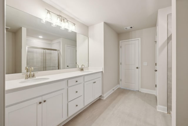 bathroom with vanity, tile patterned floors, and a shower with door