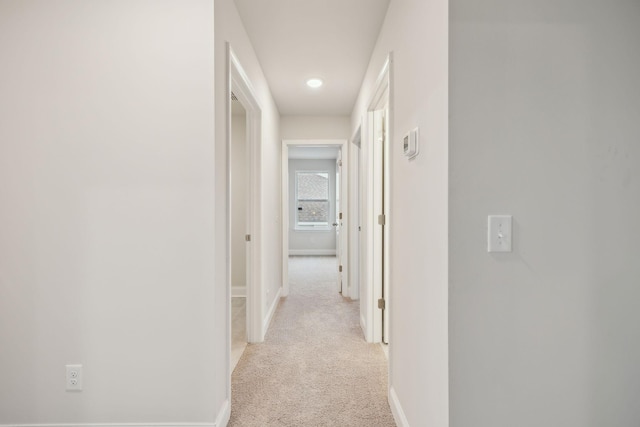 hall with light colored carpet