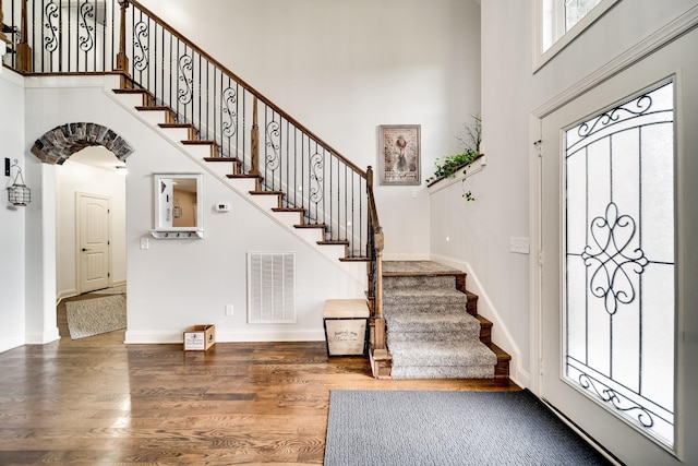 entryway with a towering ceiling and hardwood / wood-style flooring