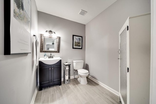 bathroom featuring hardwood / wood-style floors, vanity, and toilet