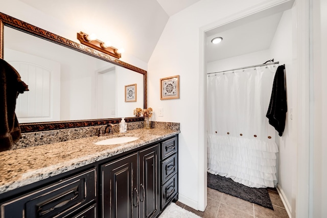 bathroom featuring tile patterned floors, vanity, and vaulted ceiling