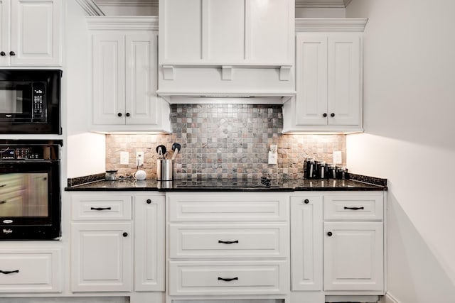 kitchen featuring tasteful backsplash, white cabinetry, dark stone counters, and black appliances