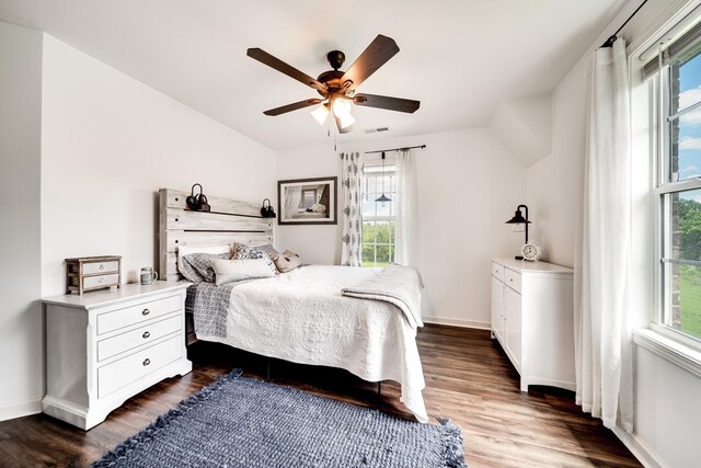 bedroom featuring ceiling fan, dark wood-type flooring, and multiple windows