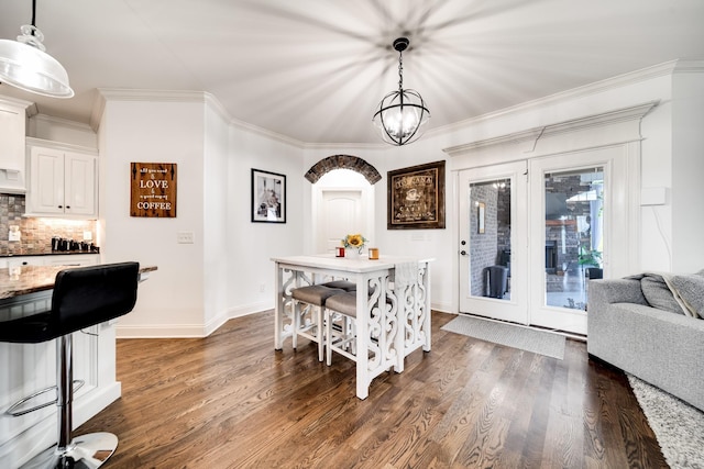 dining space featuring a chandelier, dark hardwood / wood-style flooring, and ornamental molding