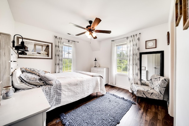 bedroom with multiple windows, ceiling fan, and dark wood-type flooring